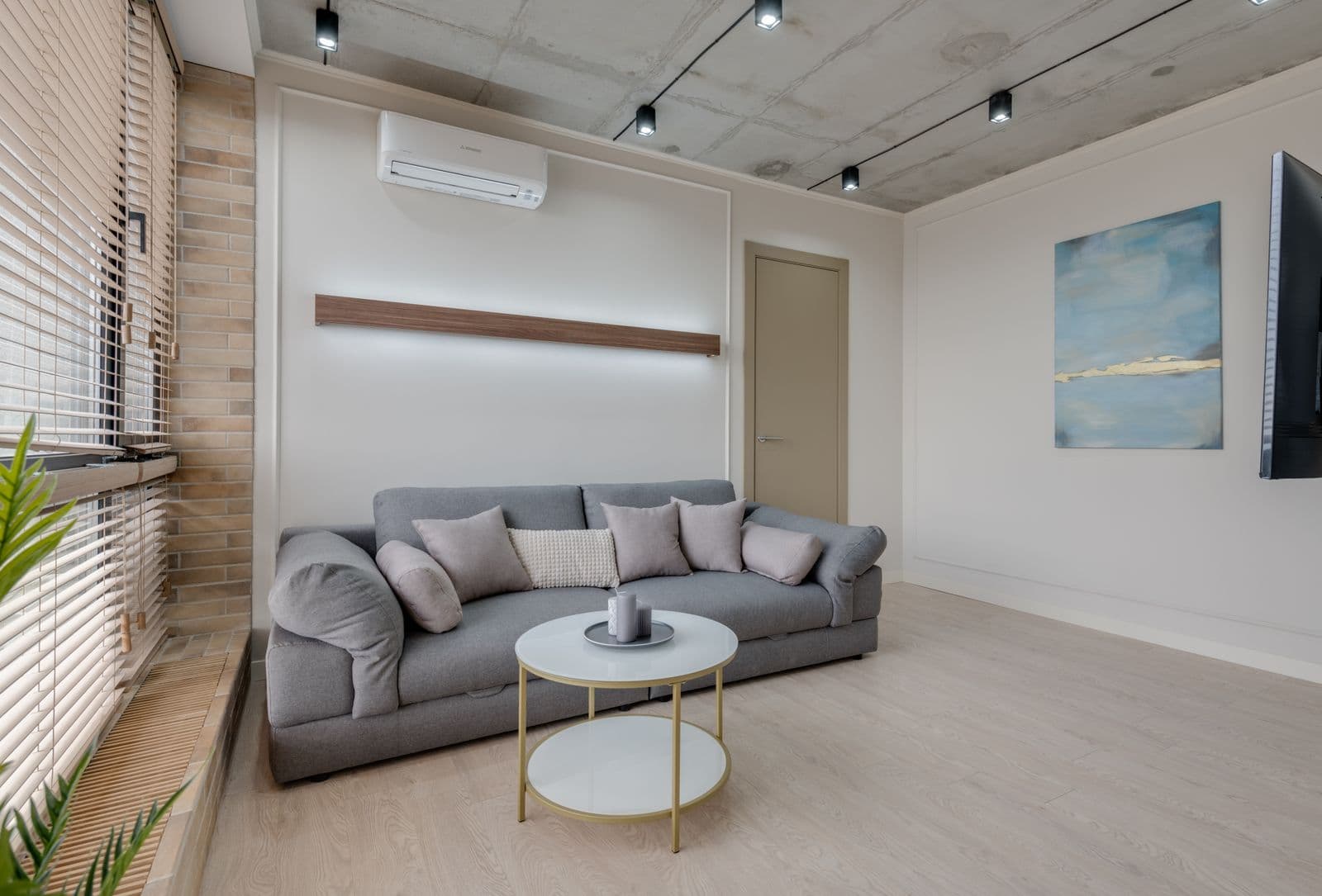 Séjour moderne avec une unité murale de climatisation au-dessus du canapé